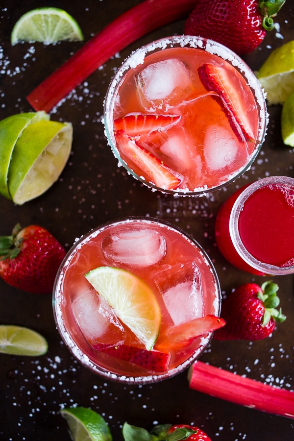 Questa margarita al rabarbaro e fragola è il modo perfetto per celebrare la primavera e il Cinco de Mayo. Il perfetto equilibrio tra dolce, crostata e tequila! Realizzato con sciroppo di rabarbaro alla fragola fatto in casa e servito perfettamente freddo sulle rocce con un bordo salato. Saluti al tuo nuovo drink estivo! 