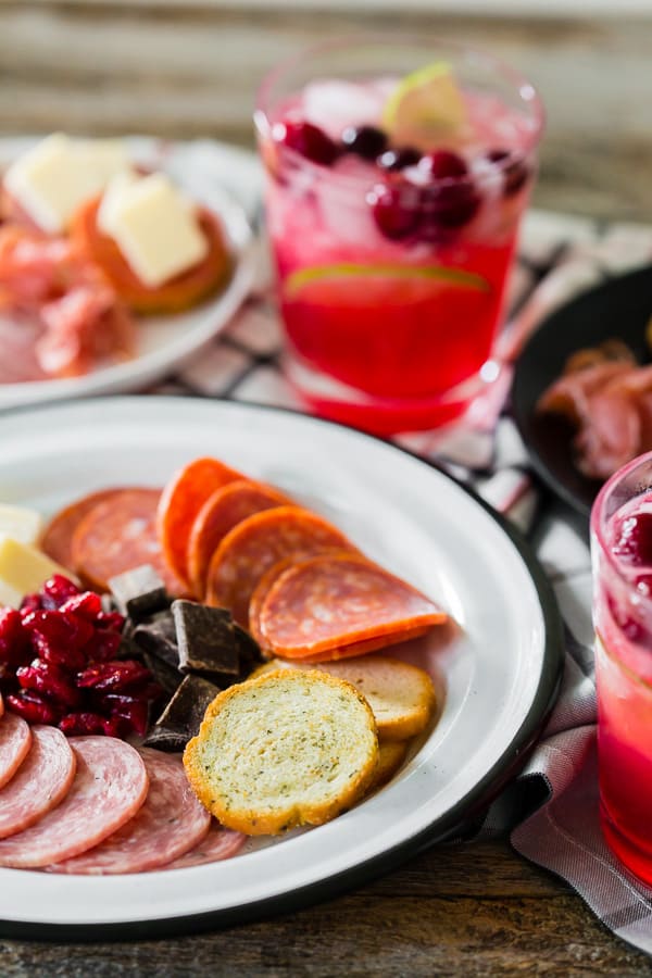 Chiuda sul colpo di carne e di formaggio su un piatto con un cocktail della birra dello zenzero della limonata del mirtillo rosso nei precedenti