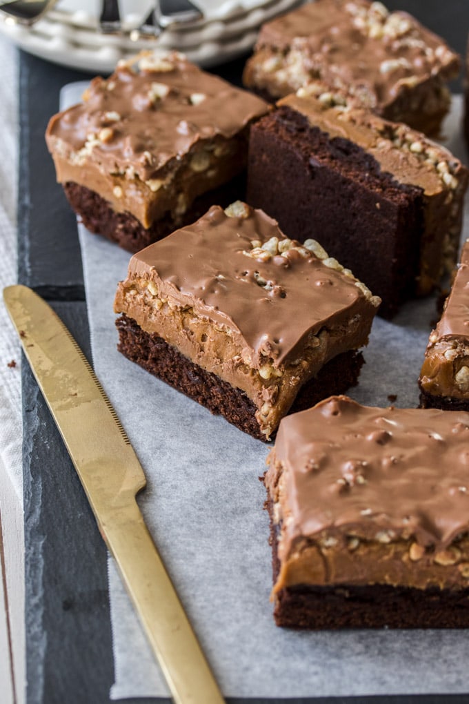 Un primer plano de Mocha Fudge Crunch Bars con un cuchillo al lado de ellos.