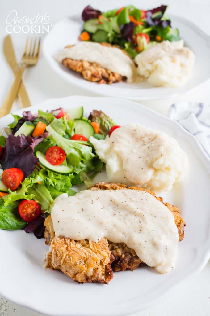 El filete de pollo frito no es bajo en grasa, pero es un alimento reconfortante. Es delicioso y una excelente manera de usar filete en cubos o incluso un corte duro de filete redondo. #comfortfood #chickenfriedsteak #beefrecipes #easydinnerrecipes #dinner #chicken #skillet #stovetopmeals filete de pollo frito con ensalada y papas en un plato