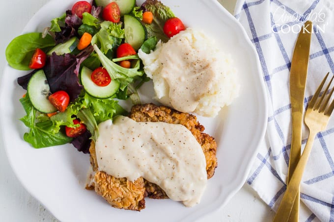 El filete de pollo frito no es bajo en grasa, pero es un alimento reconfortante. Es delicioso y una excelente manera de usar filete en cubos o incluso un corte duro de filete redondo. #comfortfood #chickenfriedsteak #beefrecipes #easydinnerrecipes #dinner #chicken #skillet #stovetopmeals filete de pollo frito con salsa y ensalada