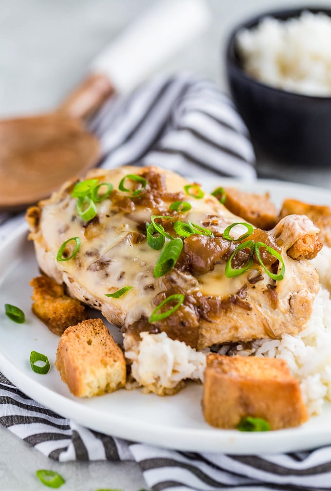 French Onion Chicken es una comida fácil de comer que encantará a toda la familia. Esta receta de pollo sartén sabe igual que su sopa favorita en forma de plato principal. Sopa de cebolla francesa El pollo es una pechuga de pollo con queso suizo, sopa de cebolla francesa, crotones y más queso. Pollo con cebolla francesa en un plato con arroz