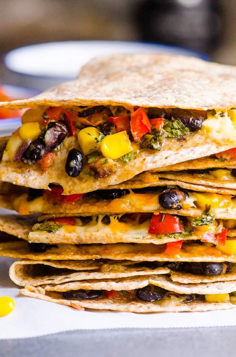 Ricetta vegetariana quesadilla sana e molto semplice con fagioli neri, verdure e una moderata quantità di formaggio nascosto in una tortilla di grano integrale al forno.  O diventa un pasto ghiacciato per notti impegnative.