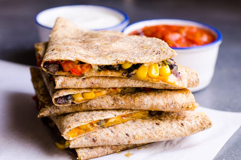 Ricetta vegetariana quesadilla sana e molto semplice con fagioli neri, verdure e una moderata quantità di formaggio nascosto in una tortilla di grano integrale al forno.  O diventa un pasto ghiacciato per notti impegnative.