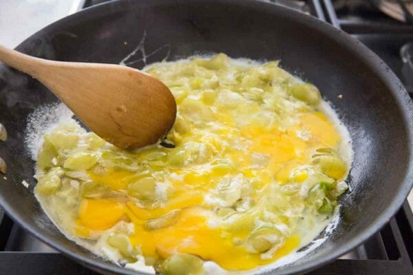 mescolare le uova in pomodori con un cucchiaio di legno