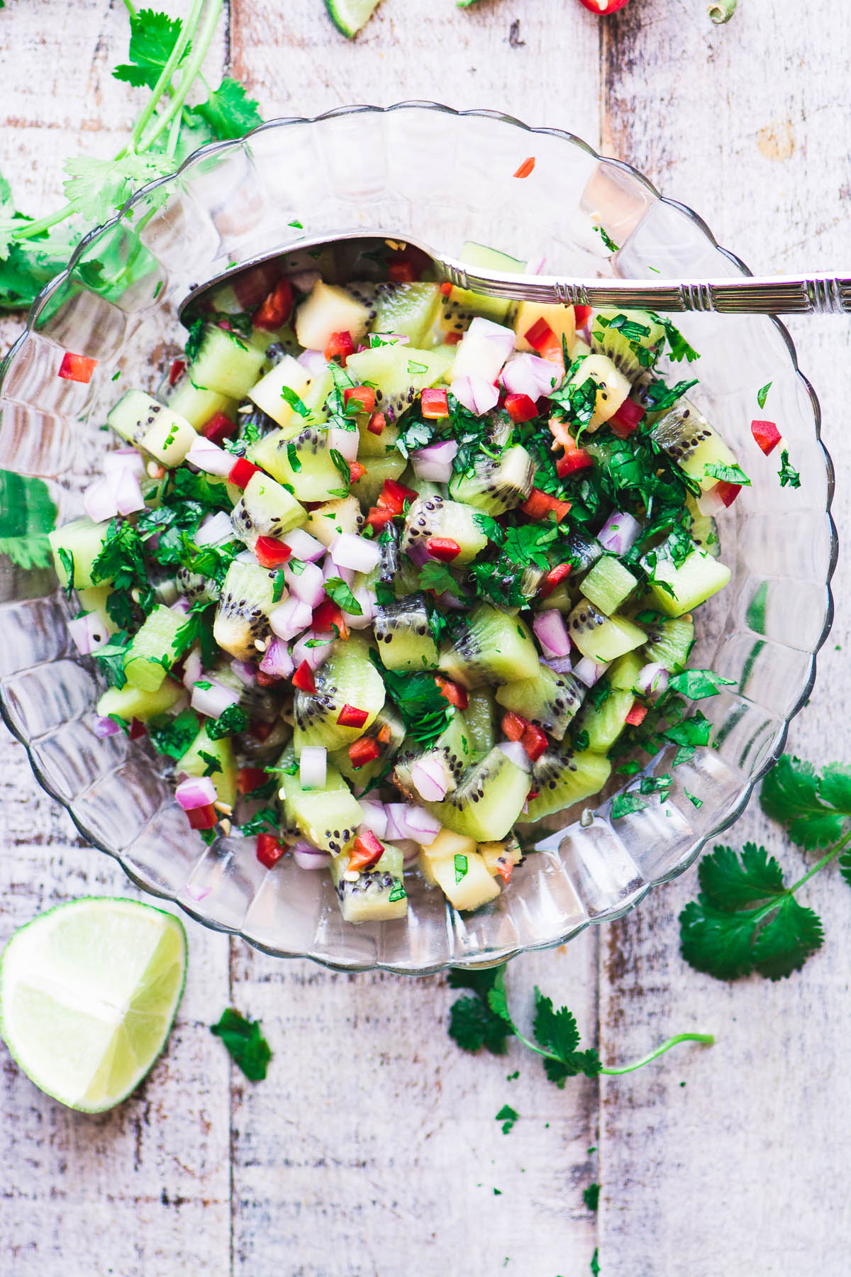 El salmón asado con salsa de kiwi picante es una comida saludable de 30 minutos con toneladas de sabor vibrante. #salmon #fish #dinner # 30minutemeal # omega3 #seafood #grilling #kiwi #salsa #oven #recipe #sheetpan #pan #lemon #easy #best #filet #glutenfree #paleo # whole30 #weightwatchers salsa de kiwi picante en un recipiente de vidrio sobre una superficie de madera