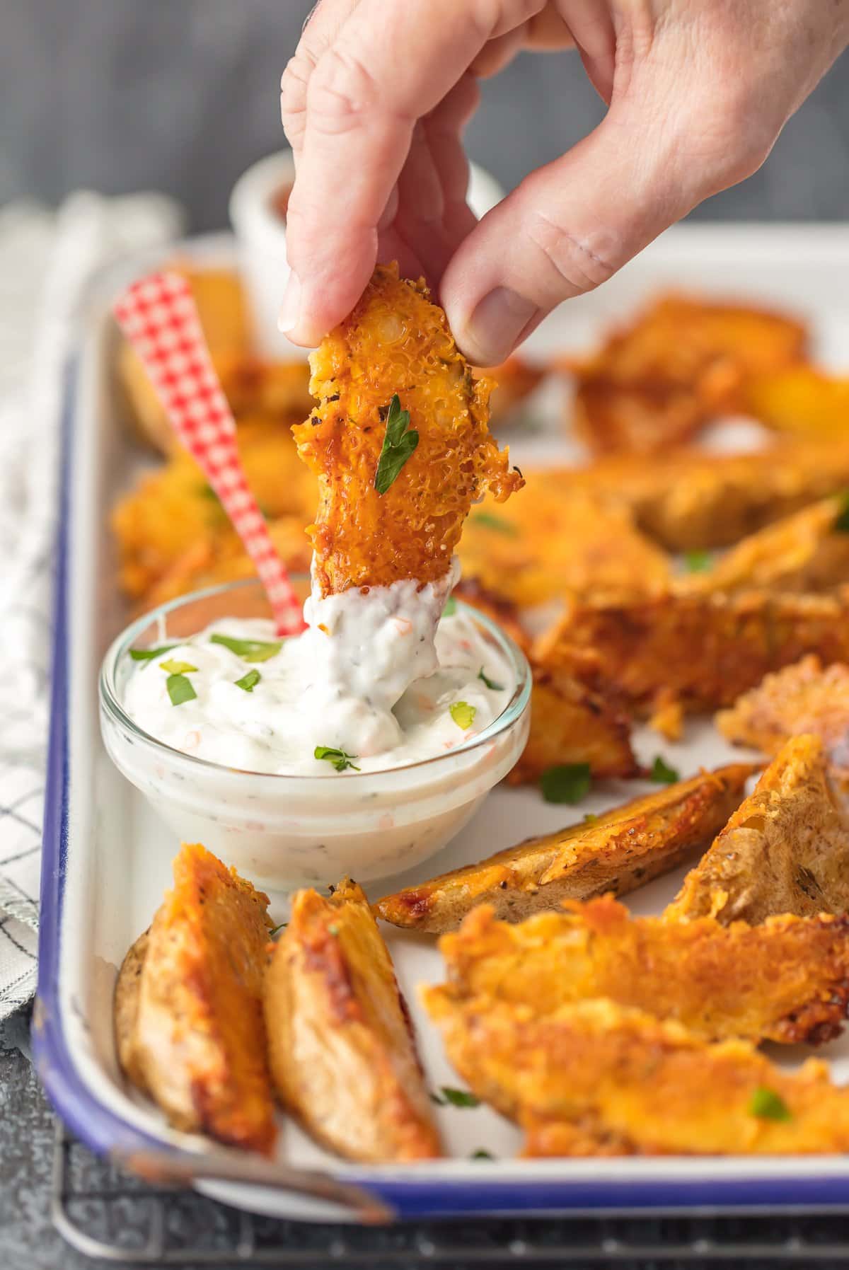 ¡Esta crujiente receta de CUÑAS DE PATATA PARMESANA es absolutamente deliciosa y FÁCIL! Nunca volverás a las papas fritas normales después de probar estas gruesas rodajas crujientes de papa al horno cubiertas con una cáscara crujiente de queso. Sumergir las rodajas de papa crujientes en la salsa