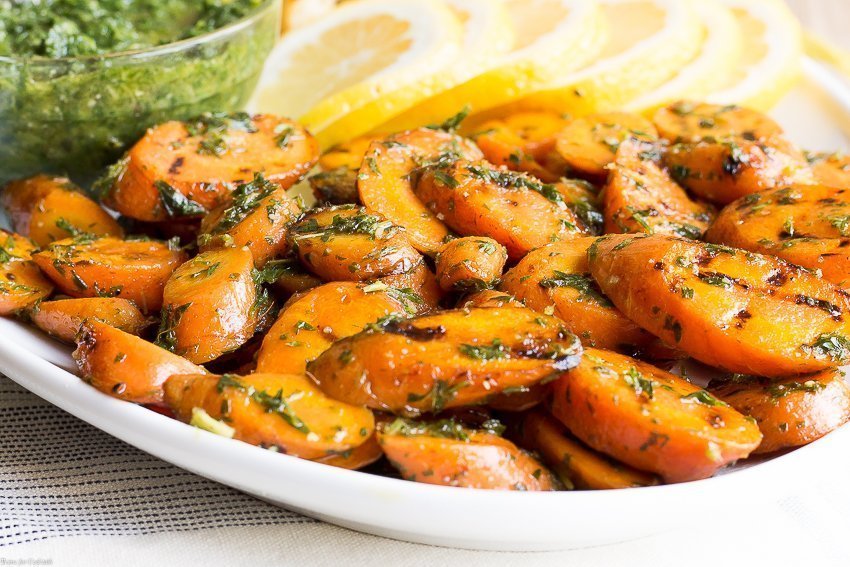 Pratica una cucina sostenibile radice-stelo durante la preparazione di questa ricetta per carote grigliate con pesto con sentori di aglio arrosto e sapori freschi e luminosi di limone.