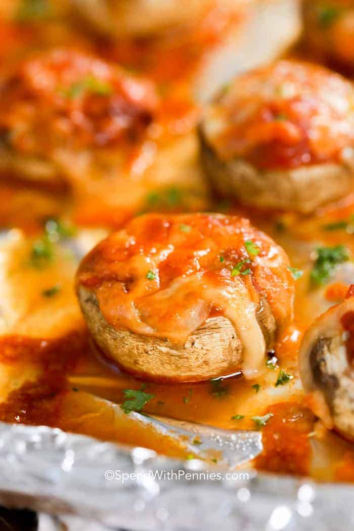 Champiñones con queso derretido y salsa en una bandeja para hornear