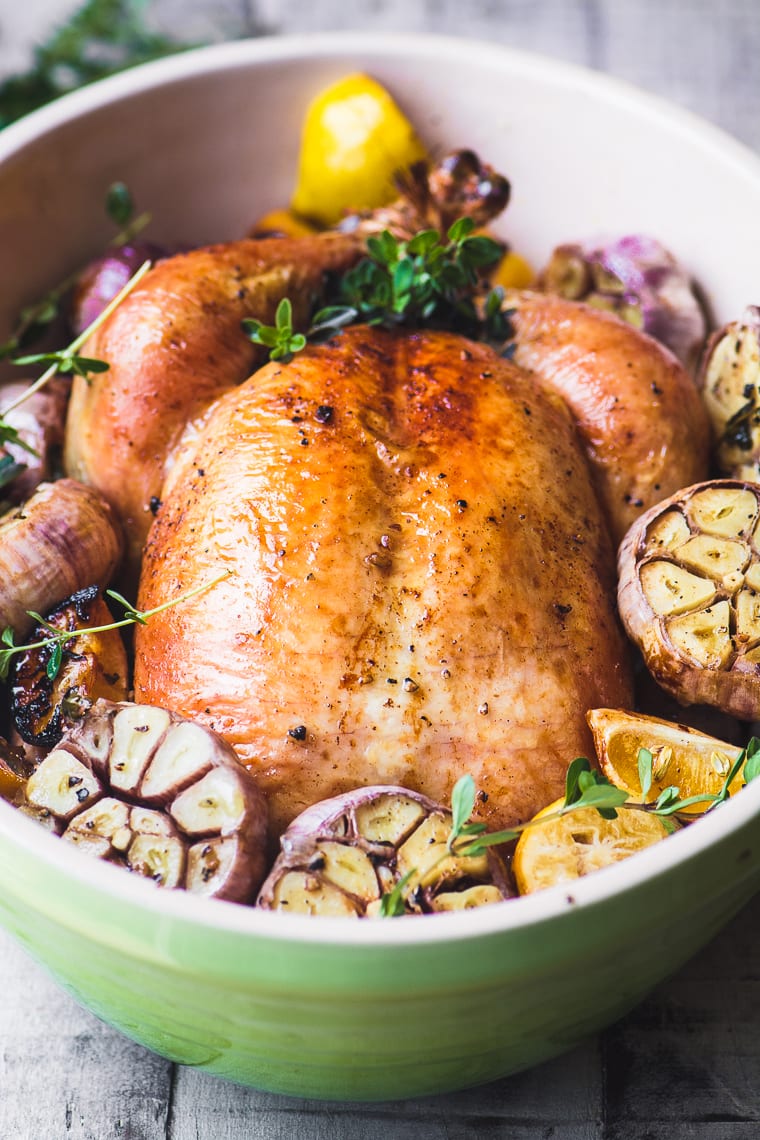 un pollo intero arrosto con aglio viola in una teglia