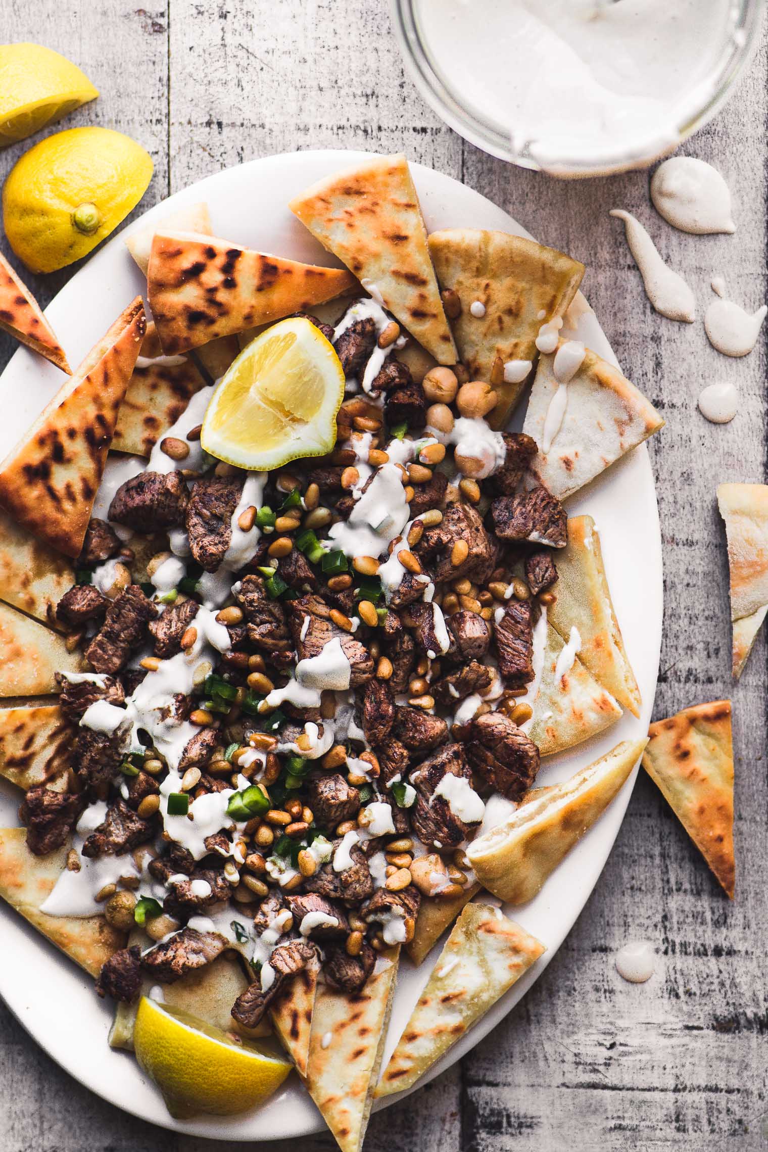 Foto aerea di un piatto di nacho mediorientale con salsa tahini