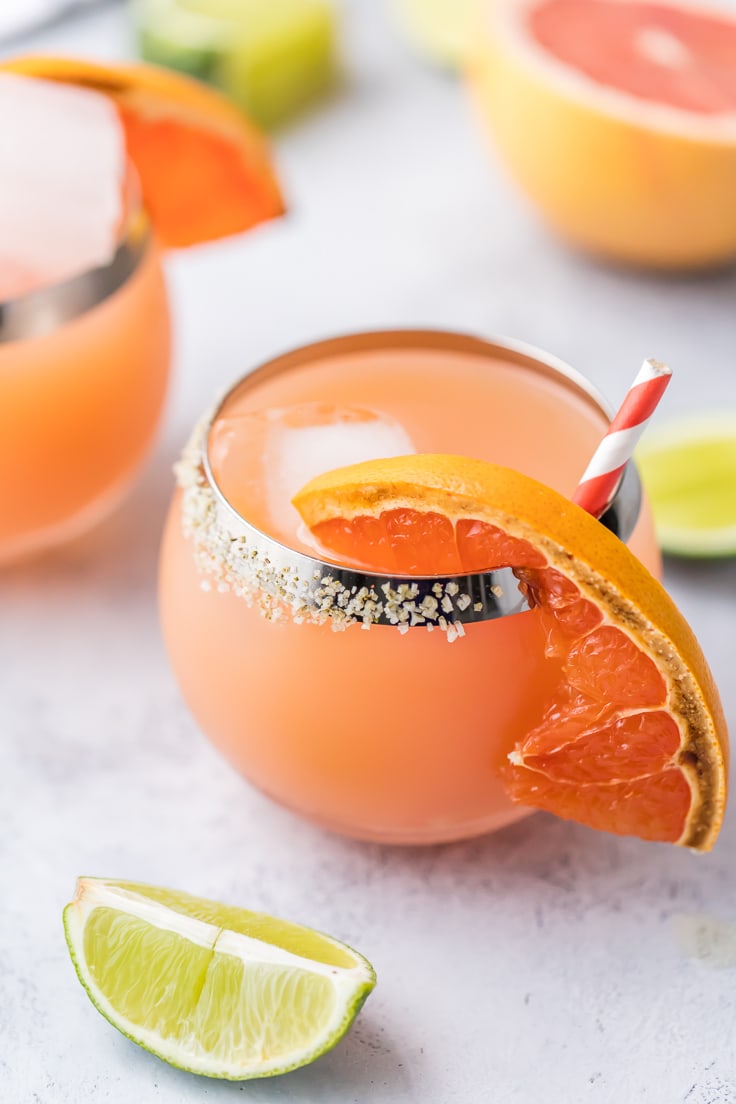 Questa margarita al pompelmo arrosto è la migliore ricetta cocktail di Cinco de Mayo! Un'ottima ricetta margarita rinfrescante e speziata, perfetta per ogni giorno d'estate, e in particolare per Cinco de Mayo! margherite rosa con fettine di pompelmo