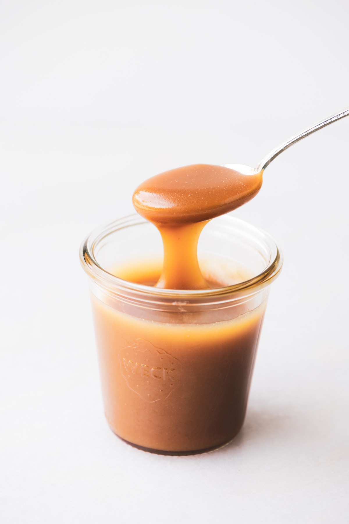salsa al caramello acero salato in un barattolo con cucchiaio