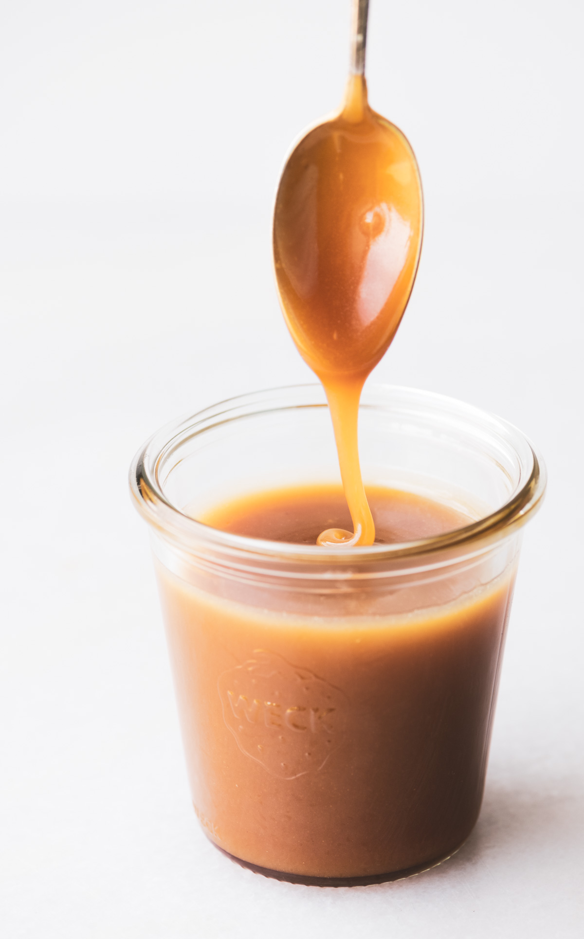un vasetto di salsa al caramello all'acero salato con un cucchiaio