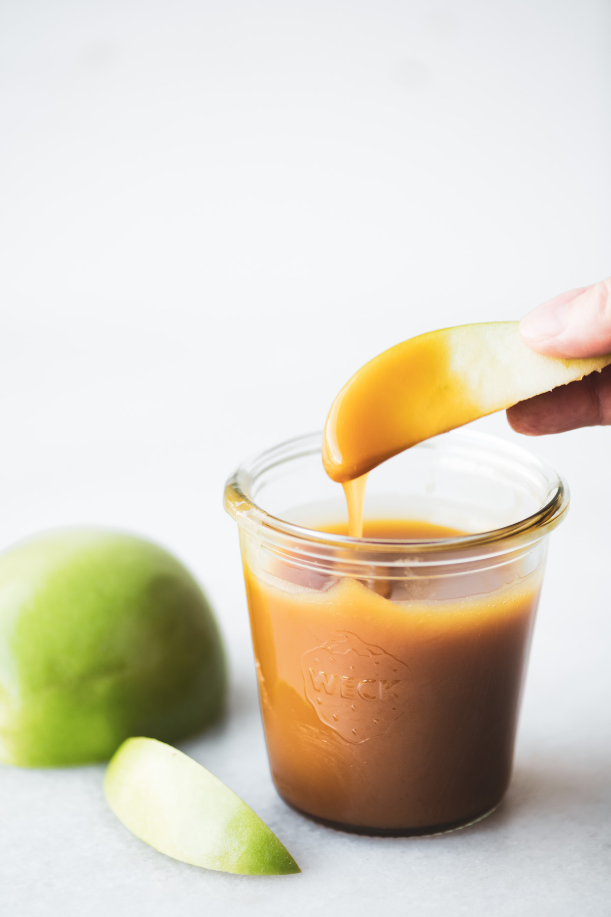 immergere una fetta di mela in salsa al caramello e acero salato