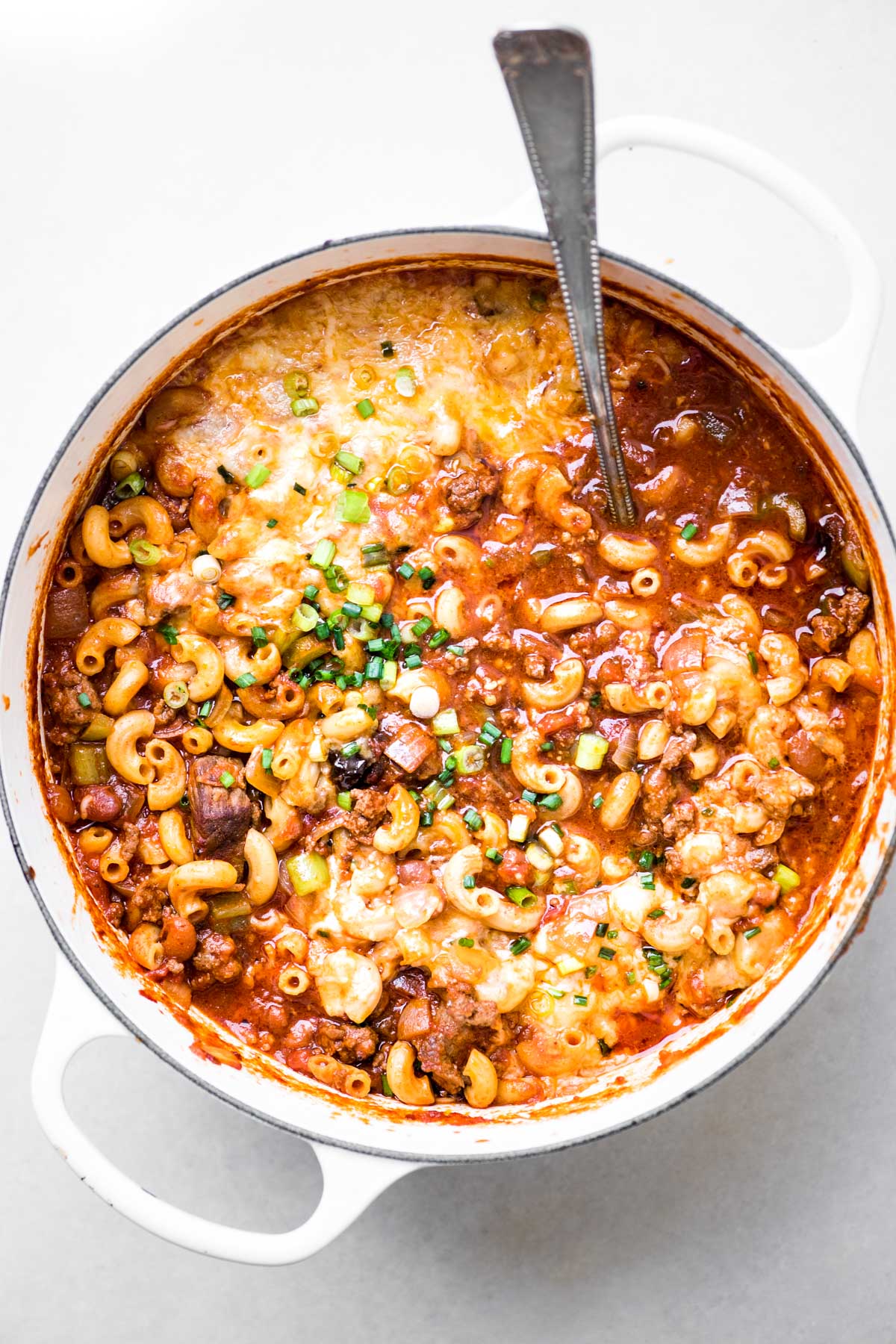una grande pentola di chili mac e formaggio con un mestolo