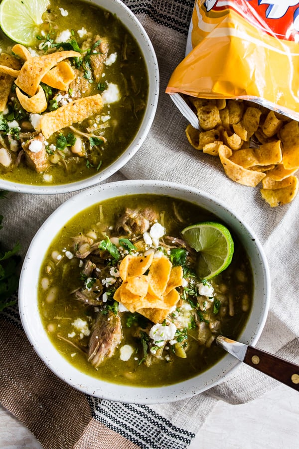 Questo chili di maiale verde istantaneo è pieno di tomatillos, coriandolo, peperoncini verdi a dadini, spalla di maiale tenera e fagioli bianchi. 
