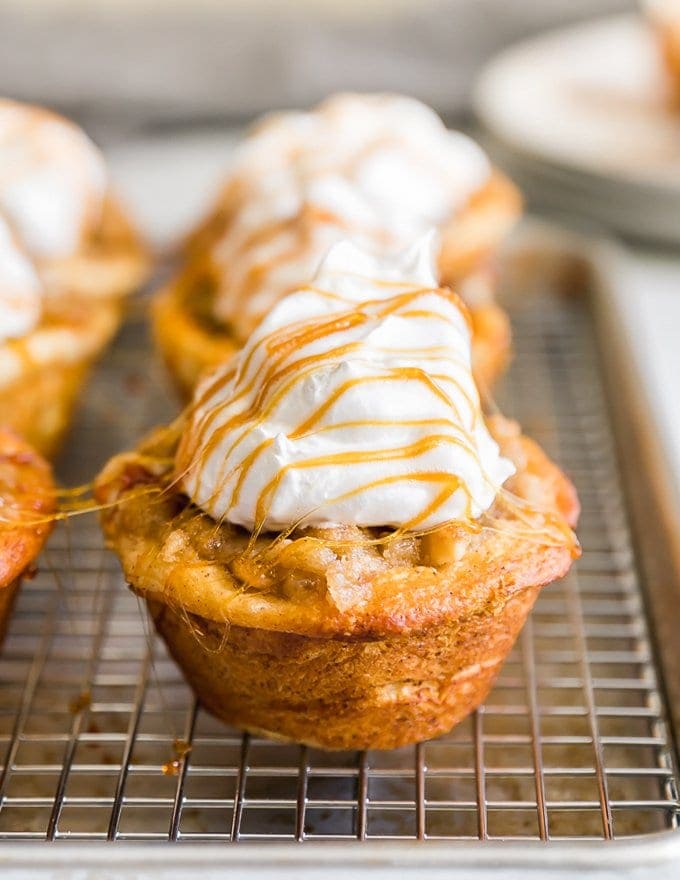 Pastelitos de tarta de manzana cubiertos con crema y jarabe de caramelo