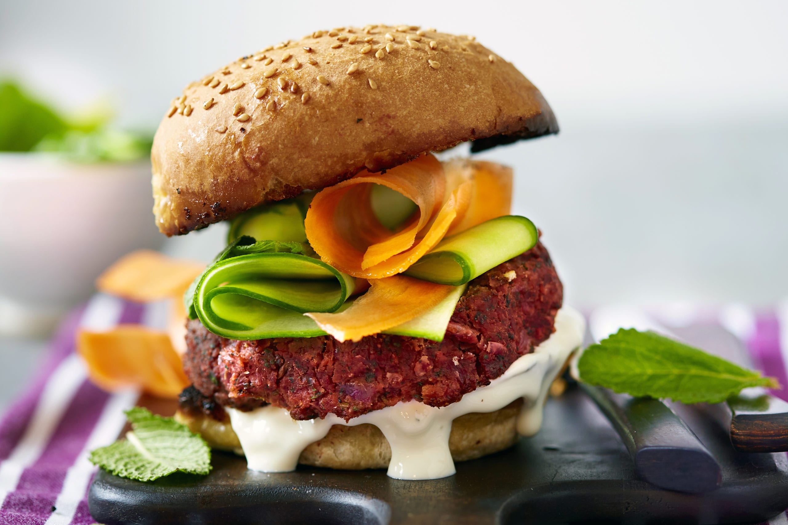 Hamburger di barbabietola Gli hamburger di barbabietola sono pieni di sapore e meravigliosamente di colore brillante. Servi con i tuoi ingredienti preferiti per gli hamburger, usiamo verdure, menta e maionese.