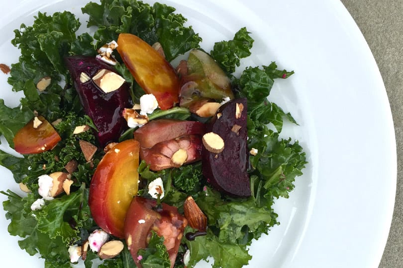 Ensalada de col rizada con remolacha asada, queso de cabra y tomates reliquia