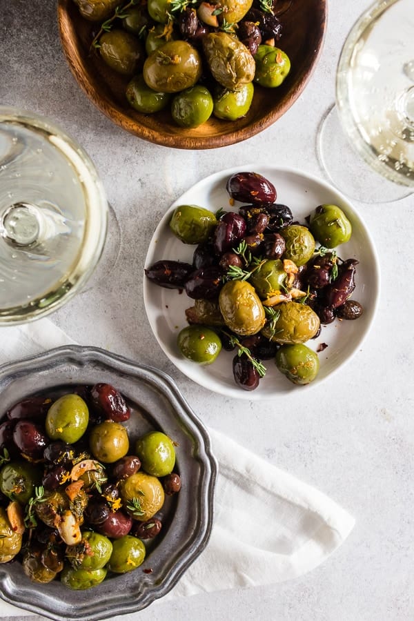 &iexcl;Estas aceitunas asadas con hierbas de ajo son el aperitivo perfecto! Son salados, llenos de ajo, tomillo y sabor a naranja y est&aacute;n listos en solo 15 minutos. Se combinan perfectamente con prosecco y seguramente impresionar&aacute;n a todos los amantes de la aceituna en su vida.