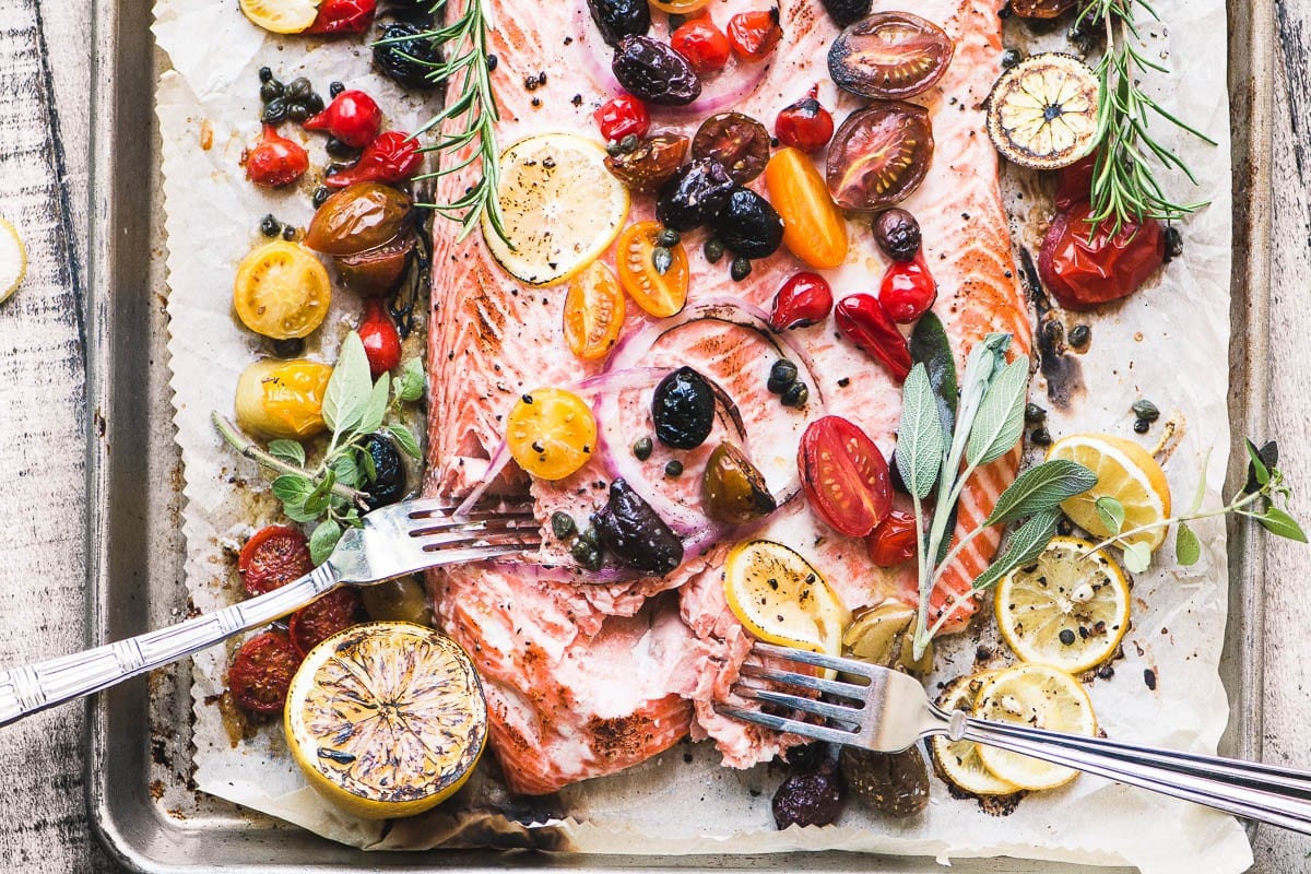 Salm&oacute;n asado mediterr&aacute;neo con tomate, aceitunas, cebolla y lim&oacute;n.