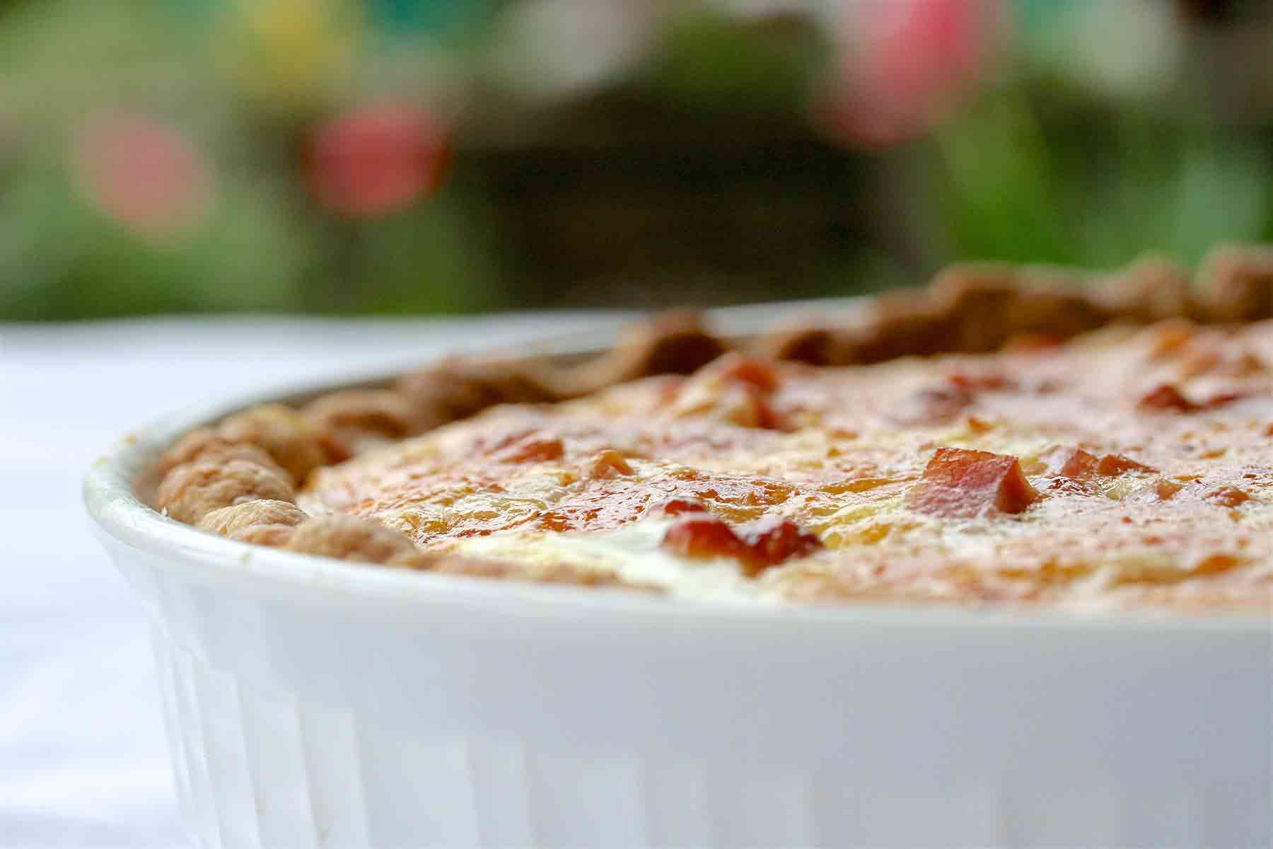 Quiche de jam&oacute;n y esp&aacute;rragos terminado en plato blanco