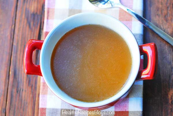 Caldo de huesos servido en un taz&oacute;n rojo