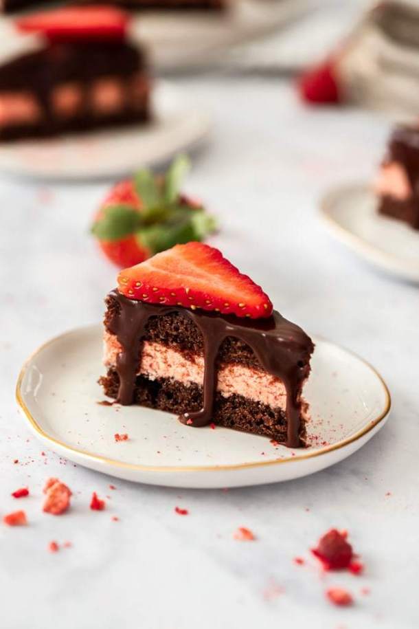 Primer plano de un chocolate petit four con una rodaja de fresa en la parte superior. Sentado en un plato blanco