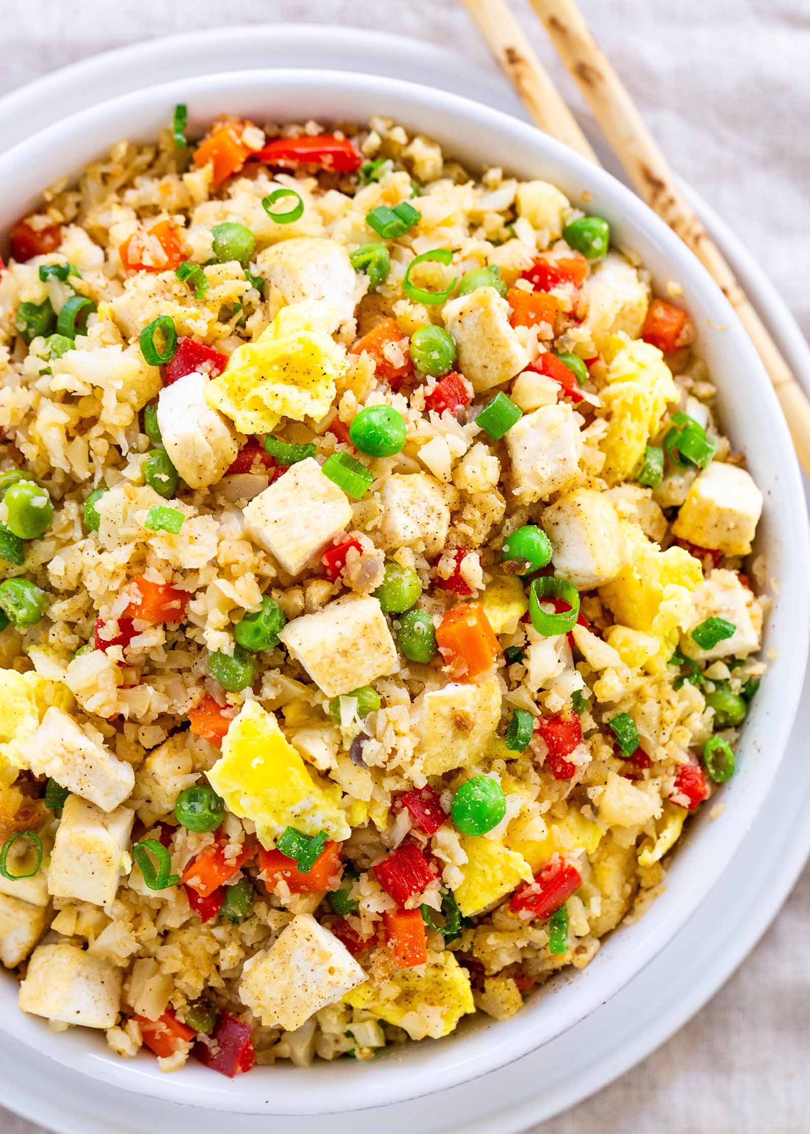 Vegetarian Cauliflower Fried Rice - - bowl of low carb fried rice with peas, eggs, and tofu