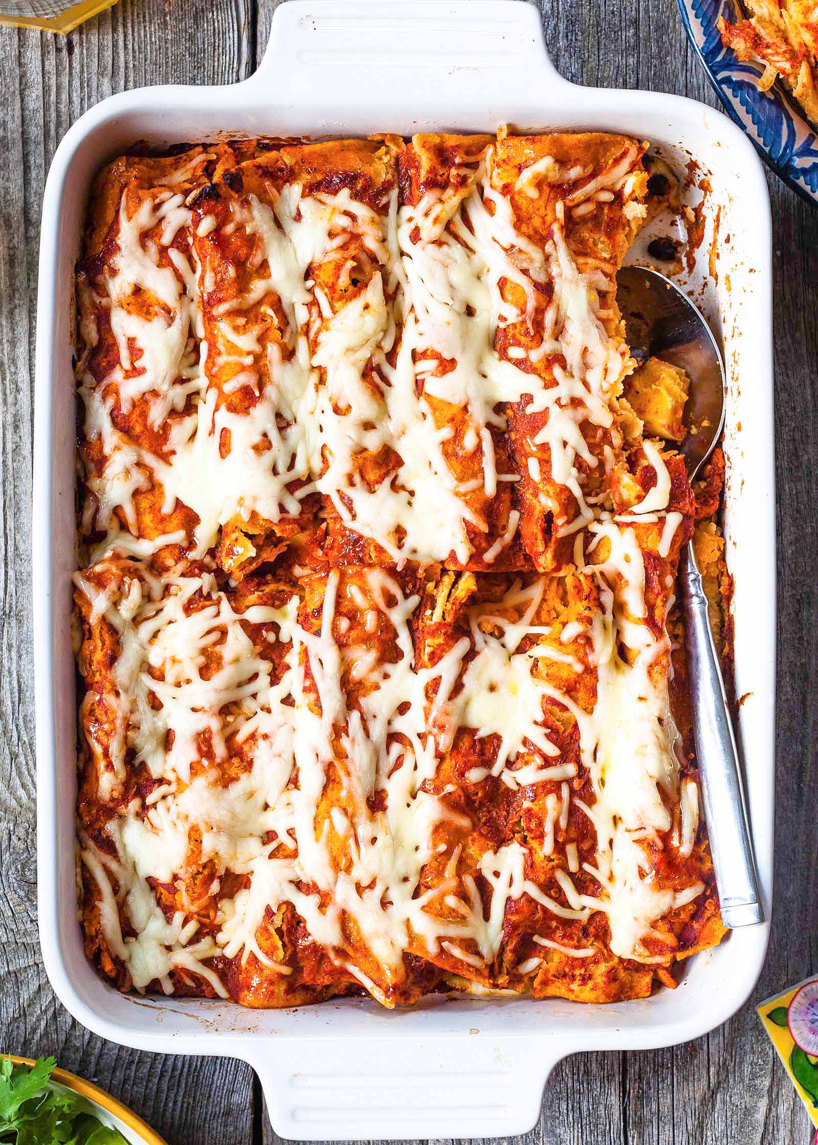 Casserole dish filled with homemade vegetairan enchiladas fillled iwth butternut squash and topped with cheese