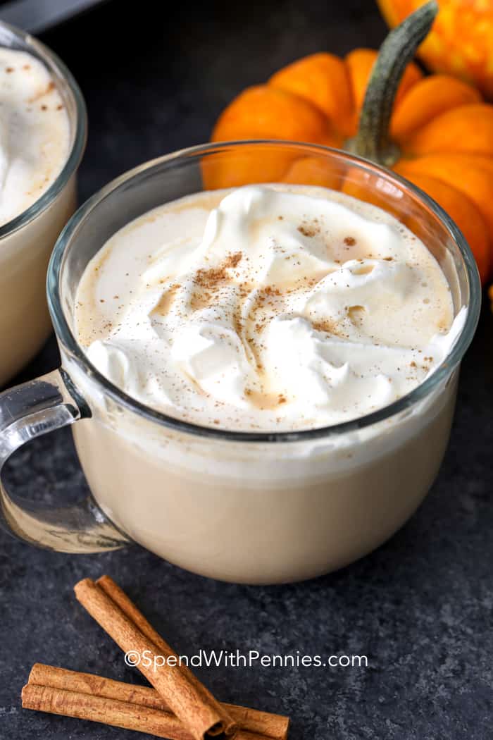 Pumpkin spice latte in a clear mug with cinnamon sticks