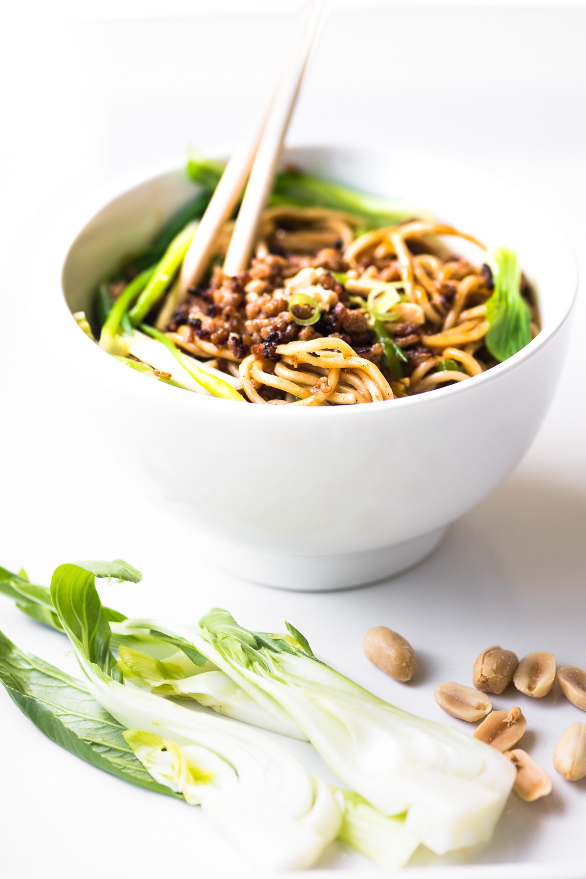 Dan dan tigela de macarrão com bebê bok choy e amendoins