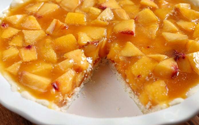 A torta de pêssego fácil é feita com uma crosta de torta muito simples, e o recheio é feito com toneladas de pêssegos frescos, geléia de pêssego, Sprite e um pouco de açúcar. Este é um dos bolos mais fáceis (e mais deliciosos) que você pode fazer!