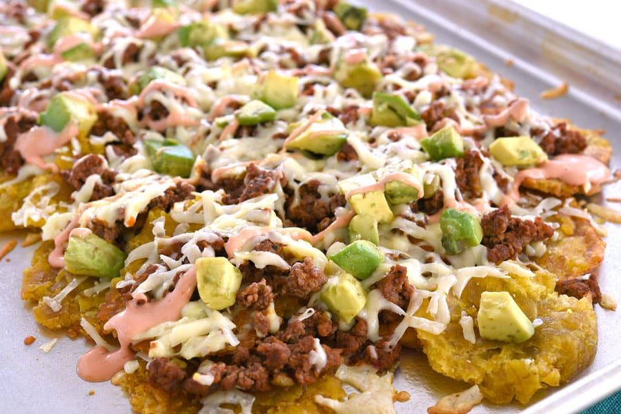 Frigideira de nachos tostona em camadas com carne moída, queijo, abacate e maionese