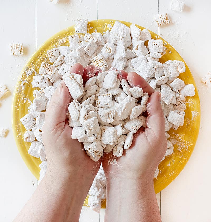 Manos llenas de pudín de plátano Puppy Chow
