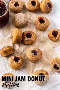 Uma pilha de muffins de mini rosquinha espalhados em um pedaço de papel manteiga coberto com açúcar de canela