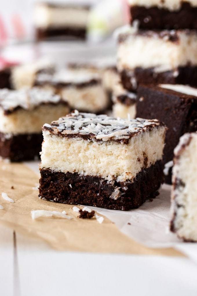 Un primer plano de un brownie de coco con otros borrosos en el fondo