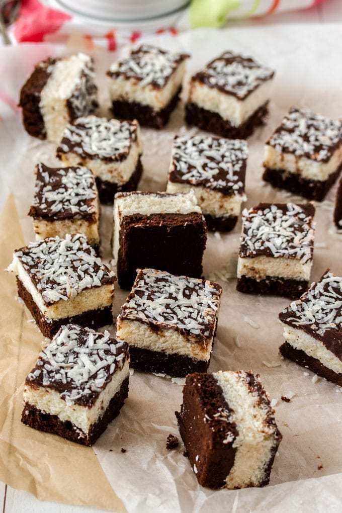 Un grupo de brownies de chocolate y coco sobre papel de hornear