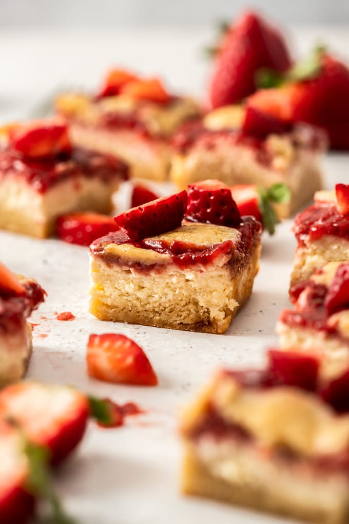 5 blondies en un plato rodeado de migas. Bayas en el fondo