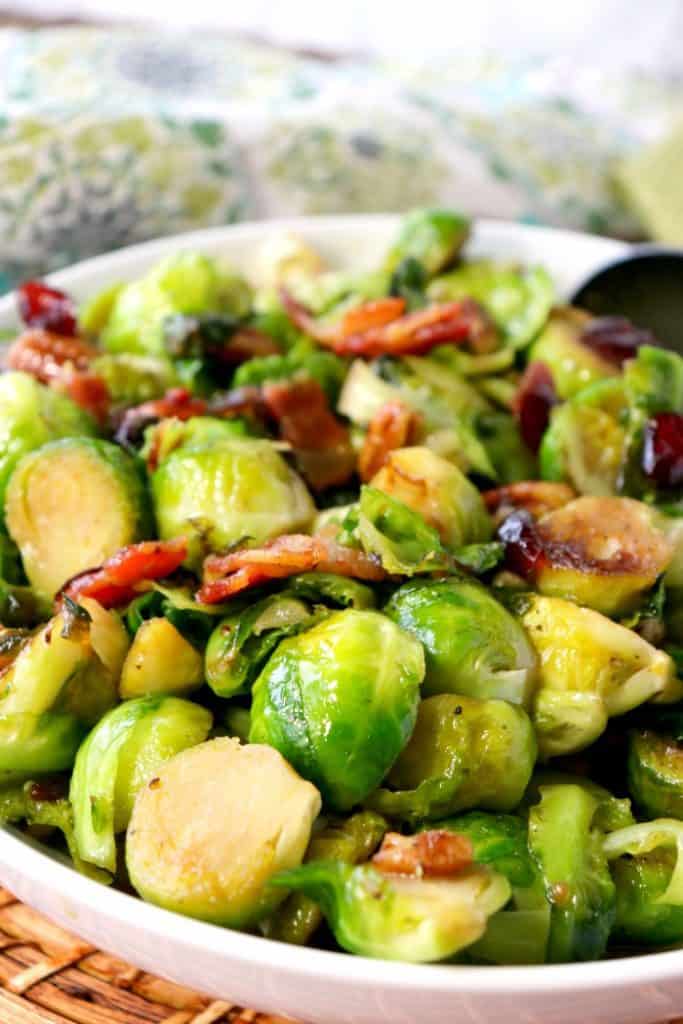Imagem vertical do close up de couves de Bruxelas sauteed com bacon cristalizado.