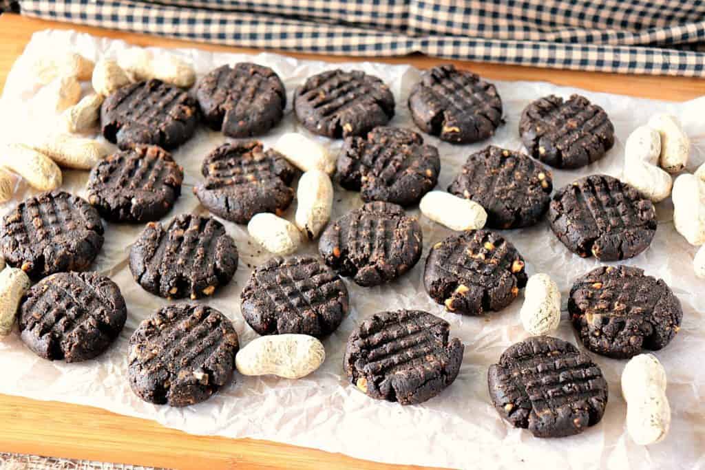 Biscoitos de manteiga de amendoim de chocolate sem açúcar de 5 ingredientes em uma placa com amendoins. - kudoskitchenbyrenee.com