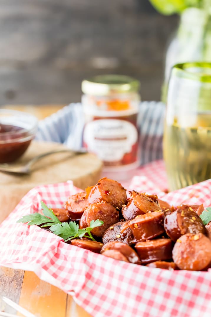 salsicha de kielbasa morde em uma cesta com papel quadriculado vermelho e branco