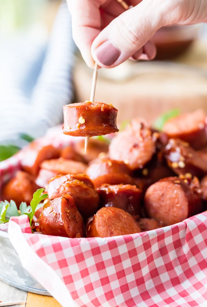 Uma cesta de kielbasa pote de barro morde, segurando uma mão para um palito de dente