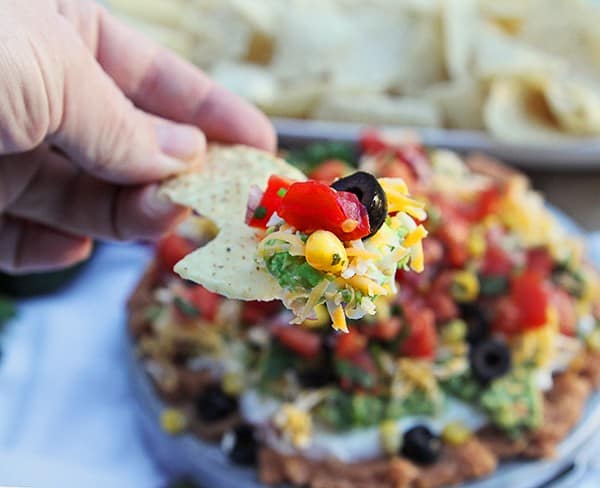 ¡Tu fiesta acaba de pasar al siguiente nivel! ¡Agregar maíz tostado a la salsa tradicional de 7 capas es absolutamente delicioso! #ambaker #appetizer #gameday #superbowlfood #sevenlayerdip Aperitivo fácil: salsa de ocho capas