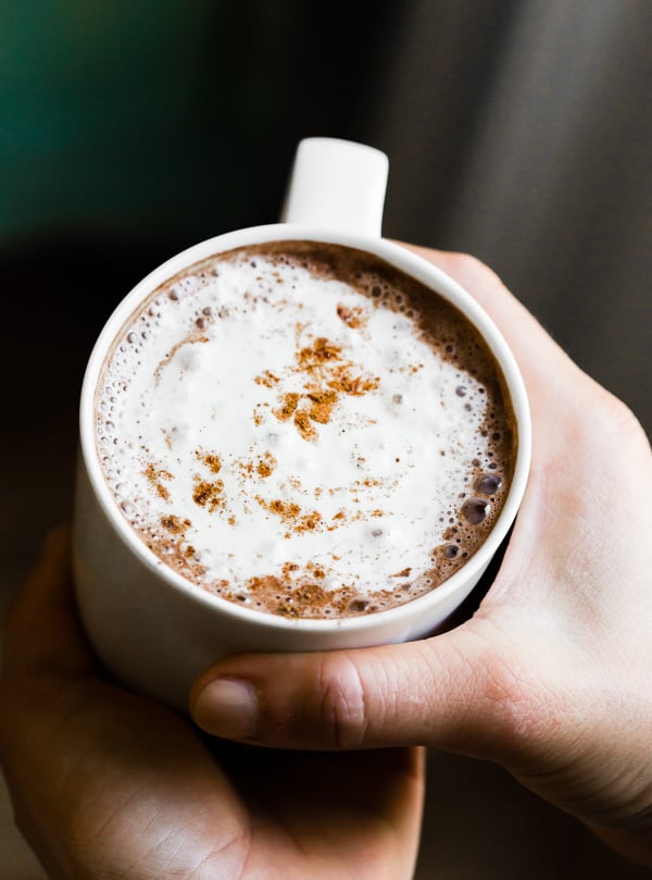Este doce e cremoso Vitamix chocolate quente está pronto em apenas 5 minutos e é feito completamente em seu Vitamix. Combine chocolate semi-doce, pó de café expresso, extrato de baunilha e apenas uma pitada de canela. Você vai adorar este chocolate quente simples e delicioso!