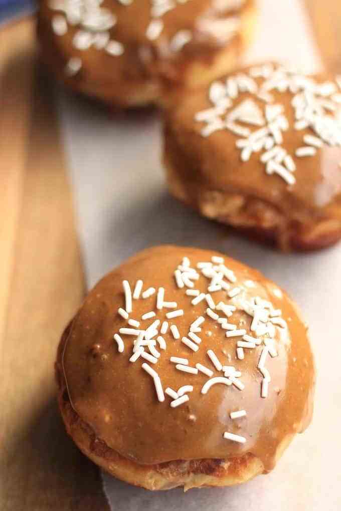 Donuts de caramelo com creme de açĂșcar mascavo de Sugar Salt Magic. Rosquinhas macias e macias com cobertura de caramelo e creme de confeiteiro
