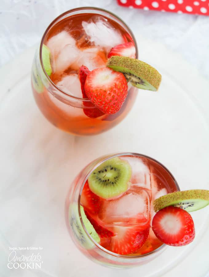 Esta sangría de kiwi y fresa es el cóctel perfecto para el verano, ya sea que lo sirva por la tarde para combatir el calor o como un cóctel divertido para acompañar una barbacoa de verano. Fotografía cenital de sangría de kiwi y fresa