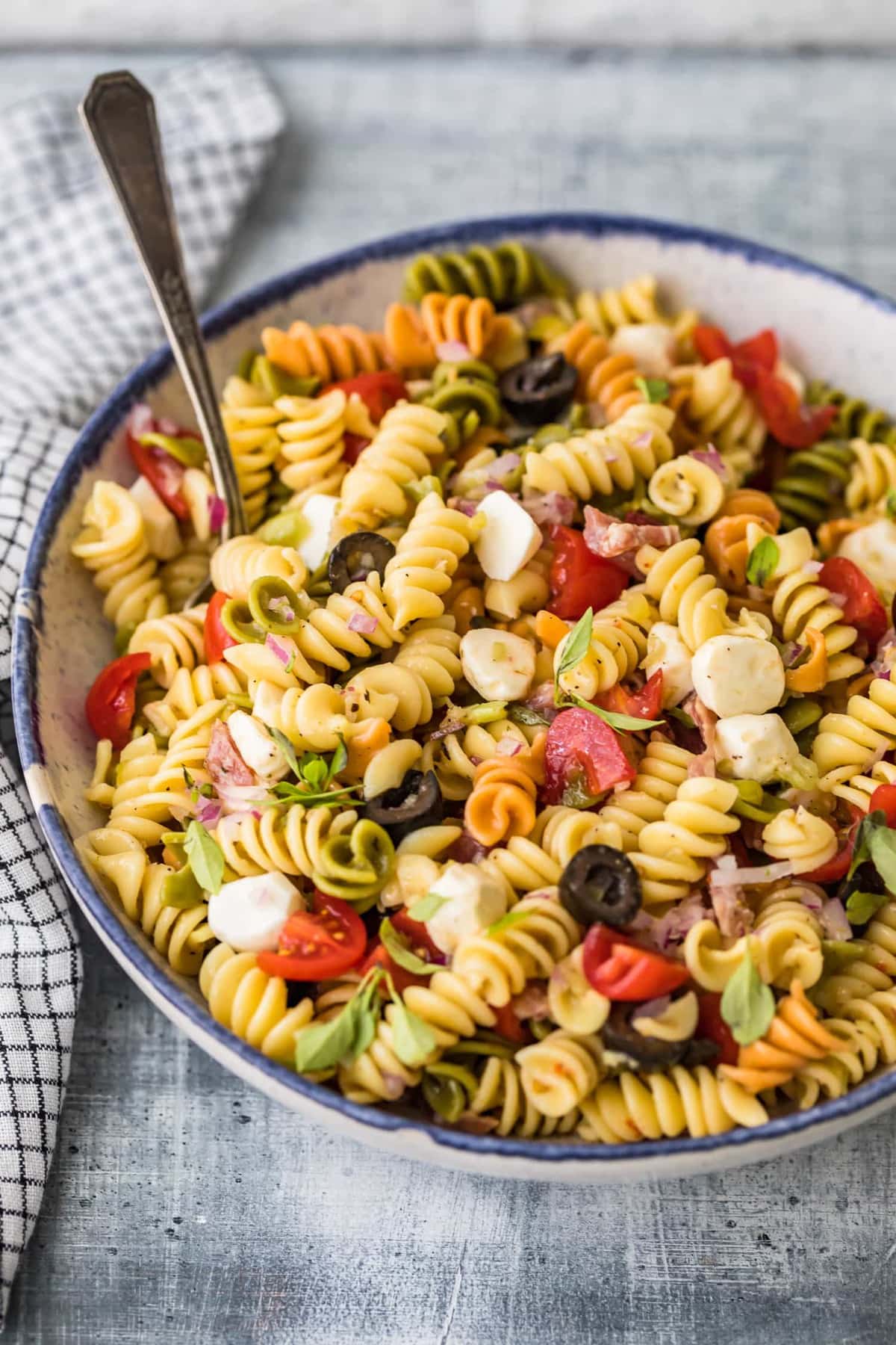 Receita de salada de macarrão italiana clássica servida em uma tigela com uma colher
