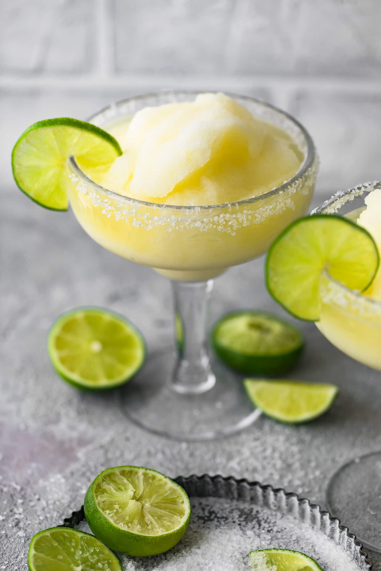 Cocktail de Margarita num copo junto às metades de limão